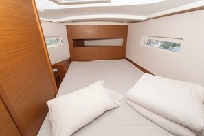 Una cabaña pequeña y luminosa con literas, paneles de madera y ventanas pequeñas.