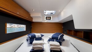 A modern room with a bed, a skylight, a mounted TV, and a framed picture on the wall. - Sun-Kissed Sailing Adventure in Sibenik, Croatia (Primošten)