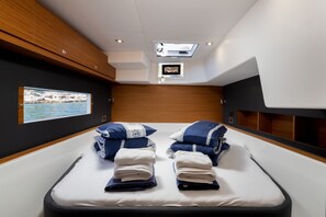 Ein modernes Zimmer mit Bett, einem Oberlicht, einem an der Wand befestigten Fernseher und einem gerahmten Bild.