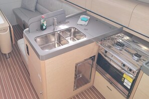 Una kitchenette funcional con pileta, hornalla y espacio de guardado.