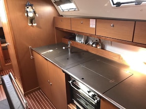A compact kitchenette with a stainless steel countertop, a built-in oven, and a small fan. - Sun-Kissed Sailing Adventure in Islas Baleares, Mallorca (Palma)