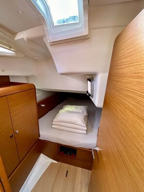 A compact cabin with a bunk bed, a small window, and a wooden cabinet. - Sun-Kissed Sailing Adventure in Zadar, Croatia (Bibinje)