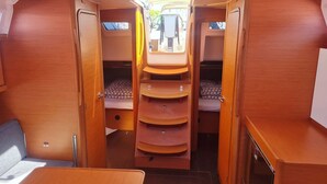 A compact RV interior with a central bed, storage cabinets, and a small seating area. - Sun-Kissed Sailing Adventure in Istria, Croatia (Pula)