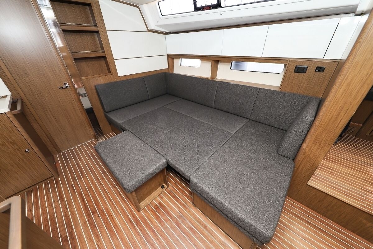 Un intérieur compact comprenant un canapé-lit, un plancher en bois et des rangements intégrés.