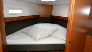 A compact bed with a headboard, a small window, and a wooden cabinet above it. - Sun-Kissed Sailing Adventure in Istria, Croatia (Pula)