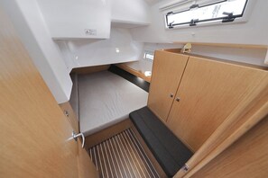 A compact interior with a bunk bed, a small window, and a storage cabinet. - Sun-Kissed Sailing Adventure in Zadar, Croatia (Biograd na moru)