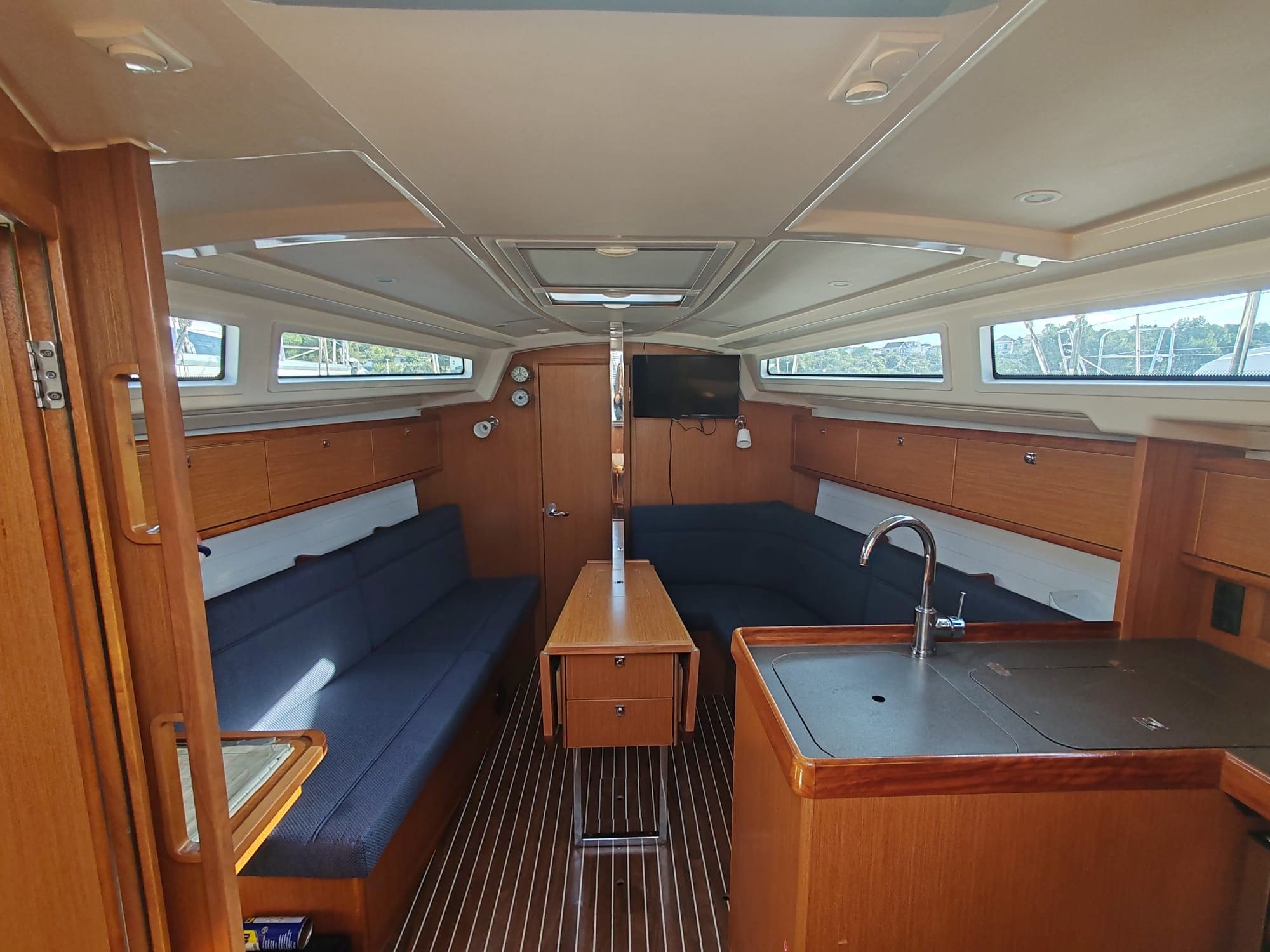 A compact galley with a central table, a sink, and seating areas on either side.