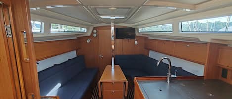 A compact galley with a central table, a sink, and seating areas on either side.