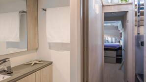 Un baño moderno con un espejo grande, un perchero, un lavamanos y una decoración con una estrella de mar.