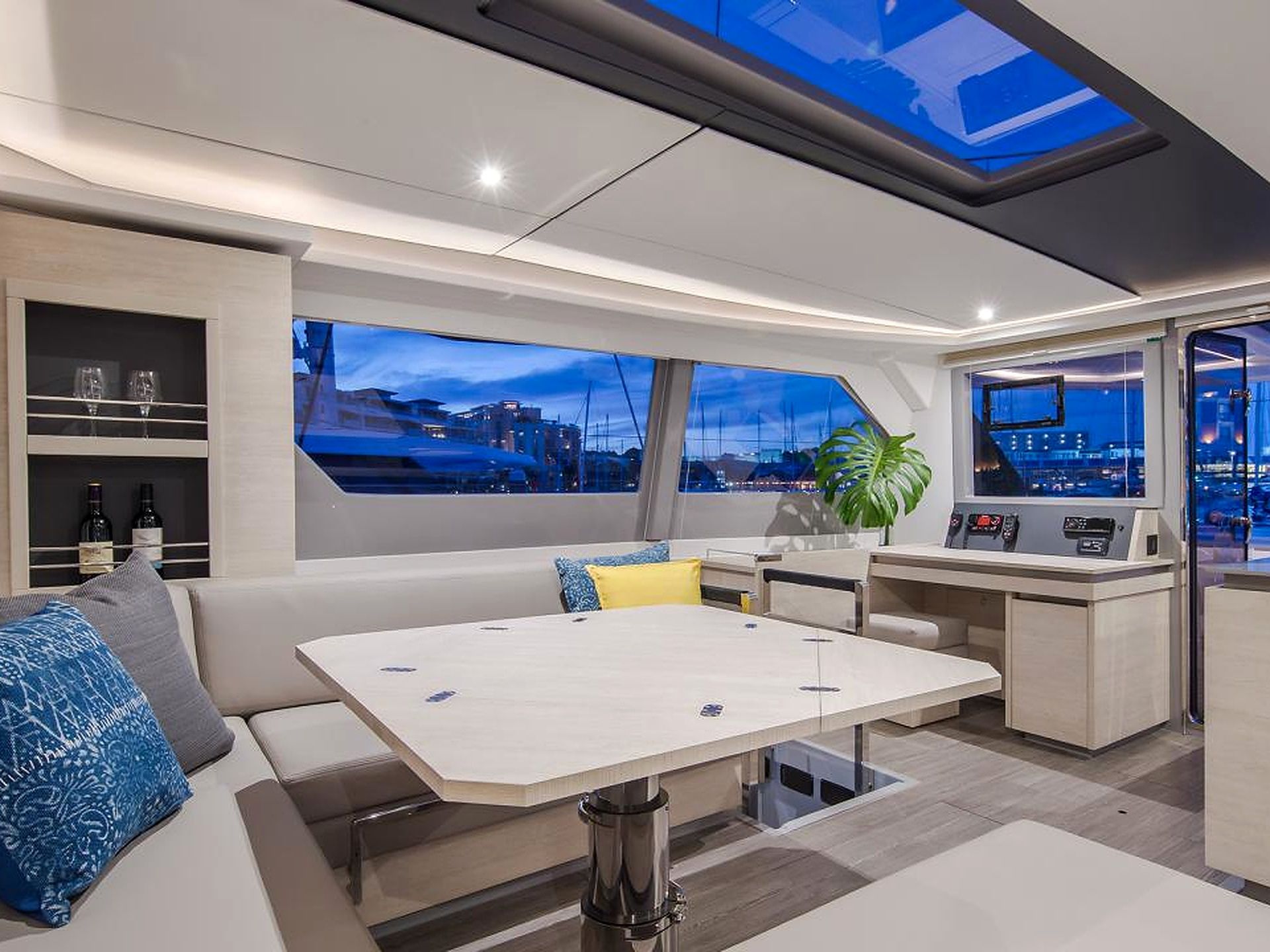 Un intérieur de yacht moderne comprenant un espace repas, des sièges et un poste de commande.