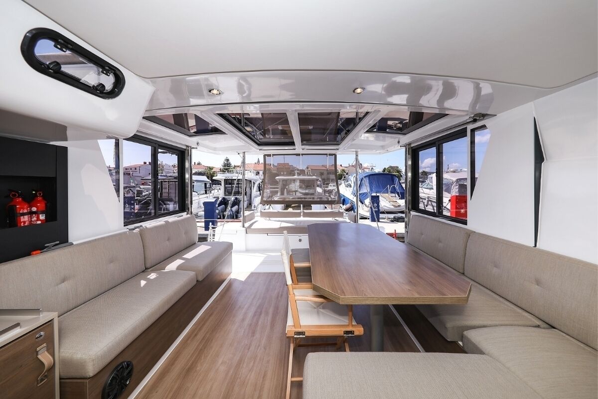 Bootinterieur met zitplaatsen, een tafel en ramen.