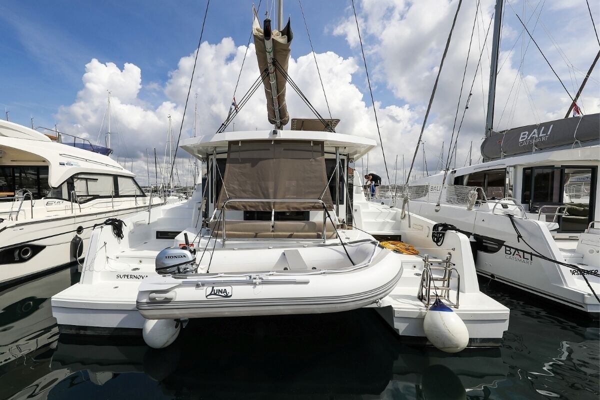 A marina with several boats docked, including a white boat with a Honda outboard motor and a cabin with a covered seating area.