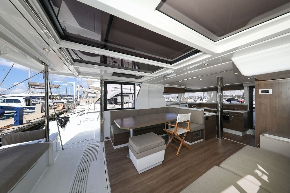 Un interior de yate moderno con comedor, cocina y zona de estar.