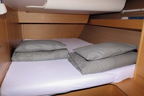 A bunk bed with two pillows, a headboard, and a light fixture. - Sun-Kissed Sailing Adventure in Zadar, Croatia (Biograd na moru)