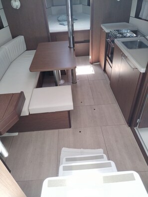 A compact kitchenette with a stove, sink, and storage cabinets. - Sun-Kissed Sailing Adventure in Northern Croatia (Punat)