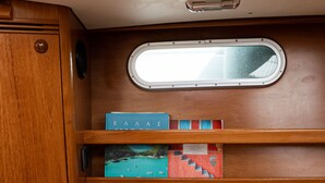 Ein Ferienhäuschen-Interieur mit Holzschnitzereien, einer gepolsterten Sitzecke und einem kleinen Fenster.