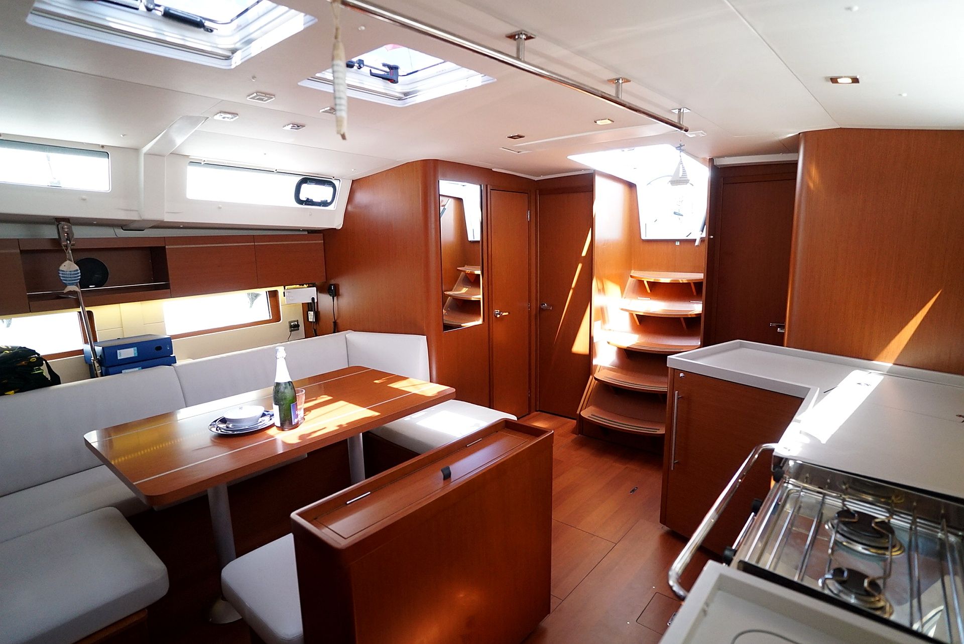 A compact kitchen with a dining area, wooden cabinets, and a small refrigerator.