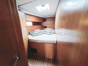 A compact cabin with a bunk bed, a small window, and a door. - Sun-Kissed Sailing Adventure in Sibenik, Croatia (Rogoznica)