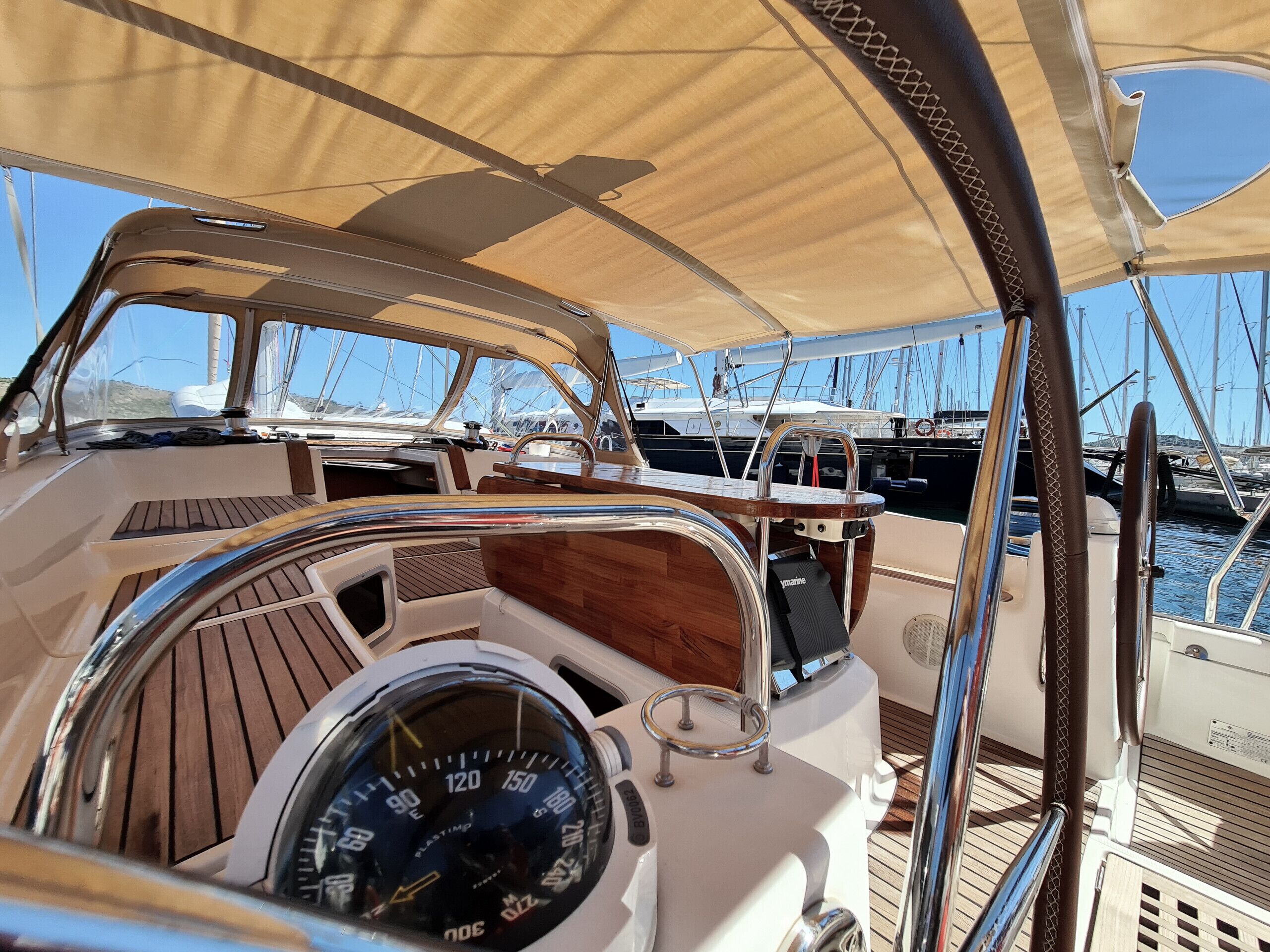 L'intérieur d'un bateau, avec un volant, des panneaux en bois et un auvent.
