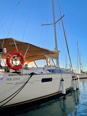 A sailboat named 'JEANNEAU 53' docked at a marina with multiple masts and a clear sky. - Sun-Kissed Sailing Adventure in Sibenik, Croatia (Rogoznica)
