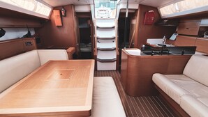 A boat interior with a dining area, seating, and a kitchen. - Sun-Kissed Sailing Adventure in Sibenik, Croatia (Rogoznica)