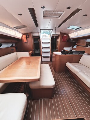 A boat interior with a dining area, seating, and a kitchen. - Sun-Kissed Sailing Adventure in Sibenik, Croatia (Rogoznica)