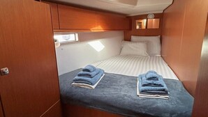 Una cabaña compacta con literas, un pequeño rincón de descanso y una ventana con vistas al cielo.