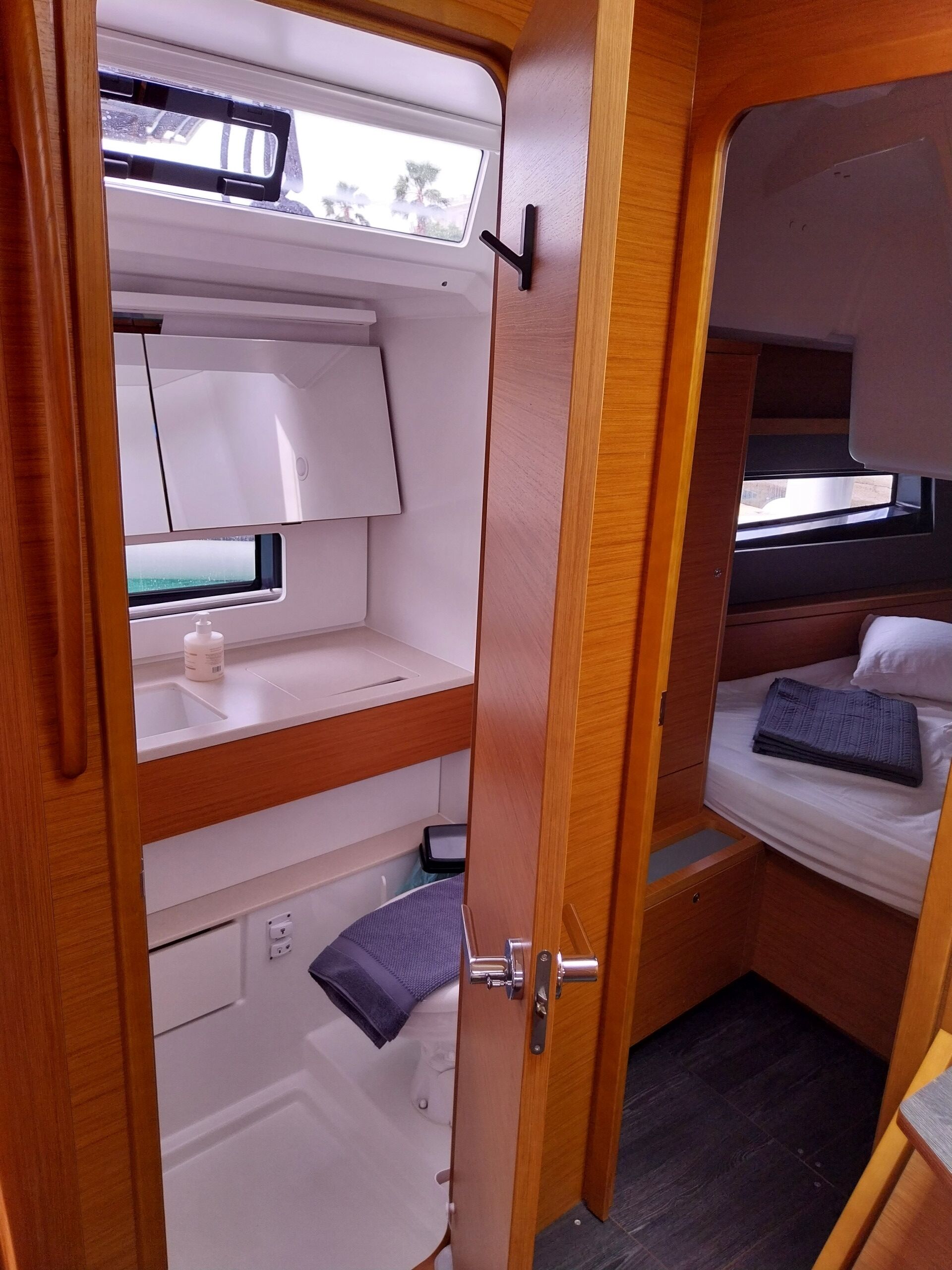 A compact interior with a bunk bed, a small window, and a door leading to a bathroom.