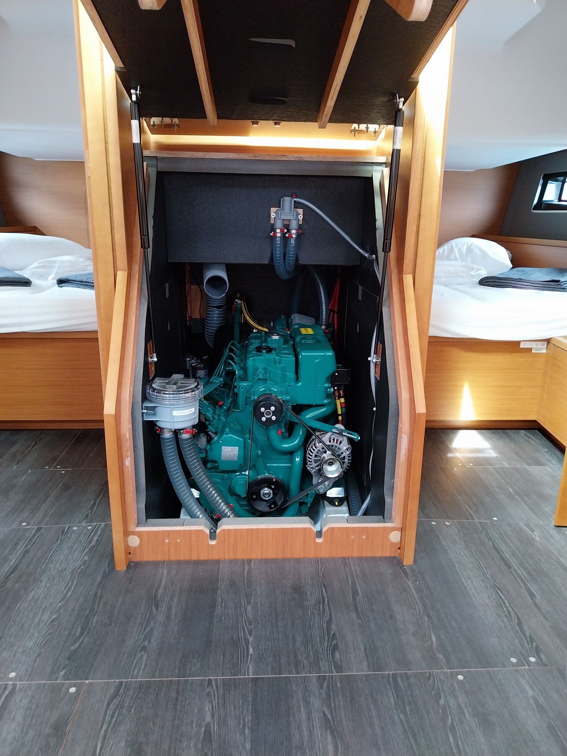 A compact room with a bed, a small table, and a visible engine compartment.