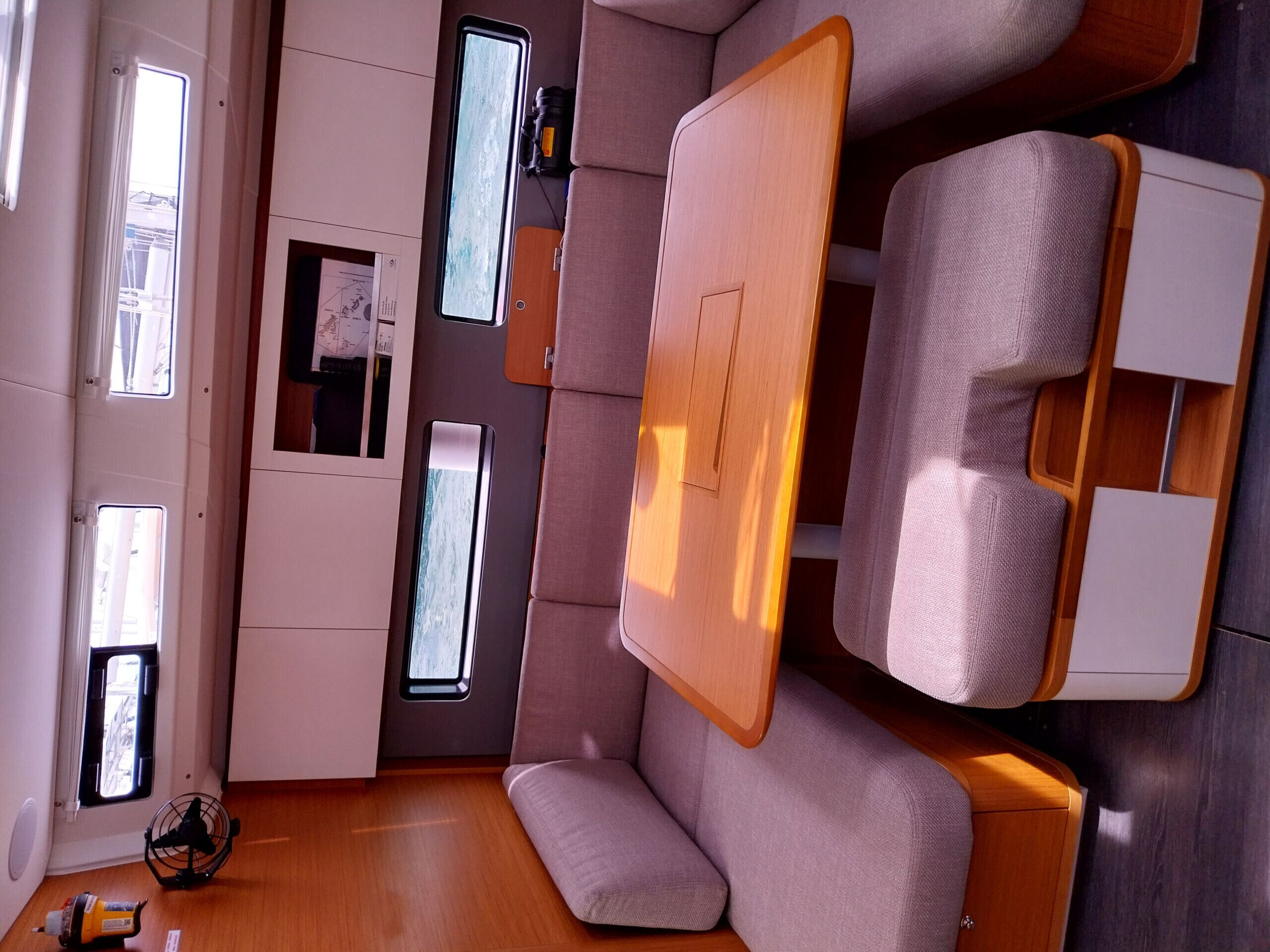 A compact, modern interior with a sofa, a small table, and a fan.