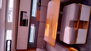 A compact, modern interior with a sofa, a small table, and a fan. - Sun-Kissed Sailing Adventure in the Sporades Islands from Volos, Thessaly (Volos)