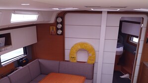 A compact interior with a wooden table, cushioned seating, a small kitchenette, and a toilet. - Sun-Kissed Sailing Adventure in the Sporades Islands from Volos, Thessaly (Volos)