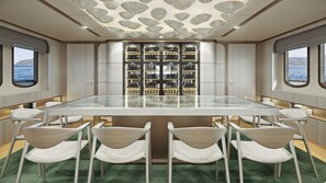 A dining area with a glass table, white chairs, a shoe display, and a view of the sea. - Sun-Kissed Sailing Adventure in Split, Croatia (Split)