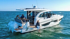 Ein Motorboot mit abgedecktem Deck, einer Sitzecke und einem Tisch.