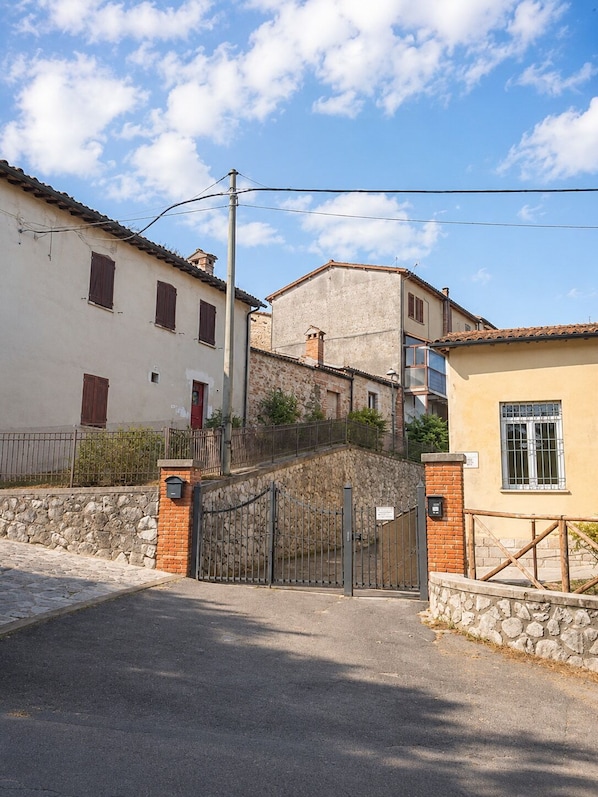 A gated entrance to a building with stone walls and a metal gate.
