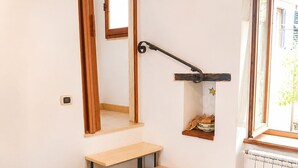 Una camera accogliente con un tavolo da pranzo in legno, una panca integrata, una piccola scala, uno specchio e una finestra con vista.