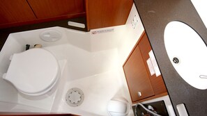Ein kleines Badezimmer mit Toilette, Waschbecken und Dusche.