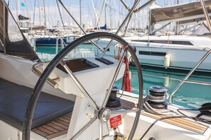 A boat's helm station with a steering wheel, control panel, and a warning label. - Sun-Kissed Sailing Adventure in the Ionian Islands, Lefkada (Lefkada)