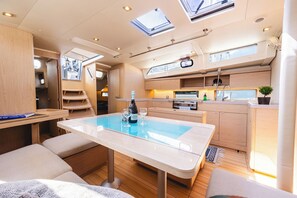 A compact kitchen with a dining area, a small sink, and a stove. - Sun-Kissed Sailing Adventure in the Ionian Islands, Lefkada (Lefkada)