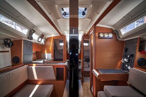 A well-lit interior with a central aisle, wooden cabinetry, and seating areas. - Sun-Kissed Sailing Adventure in Zadar, Croatia (Biograd na moru)
