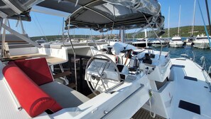 A boat deck with a steering wheel, control panel, and seating area. - Sun-Kissed Sailing Adventure in Zadar, Croatia (Biograd na moru)