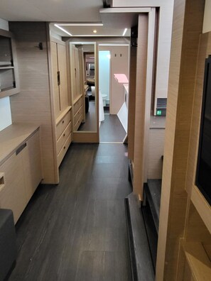 A narrow hallway with wooden cabinets and a dark floor. - Sun-Kissed Sailing Adventure in Zadar, Croatia (Biograd na moru)