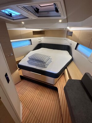 Una cabaña compacta y moderna con cama, espacio de almacenamiento integrado y tragaluces.