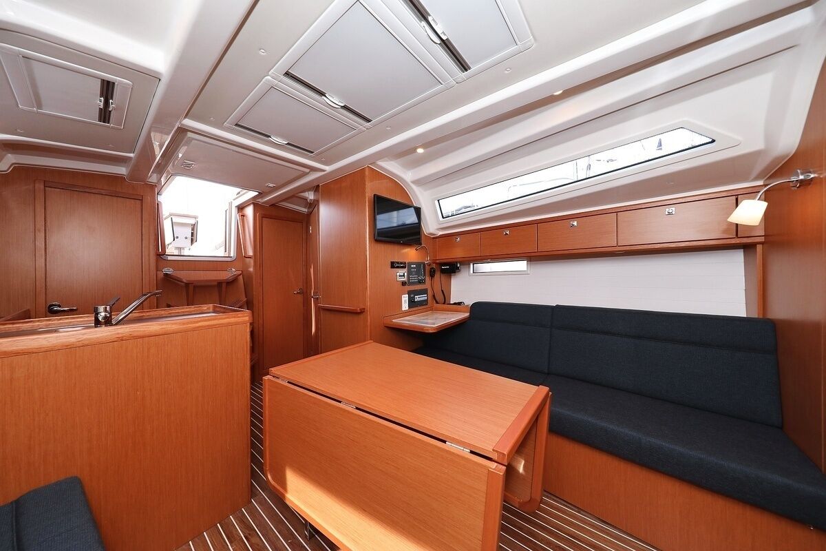 A compact galley with a wooden table, a bench, and a small seating area.