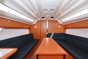 Uma cabana com uma mesa central, dois sofás e painéis de madeira.