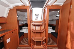 A compact interior with two bunks, a central shelf, and a small window at the end. - Sibenik Sun-soaked Sailing: A Luxurious Croatian Voyage (Pirovac)