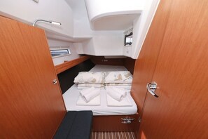 A compact cabin with a bed, a small window, and a wooden door. - Sibenik Sun-soaked Sailing: A Luxurious Croatian Voyage (Pirovac)