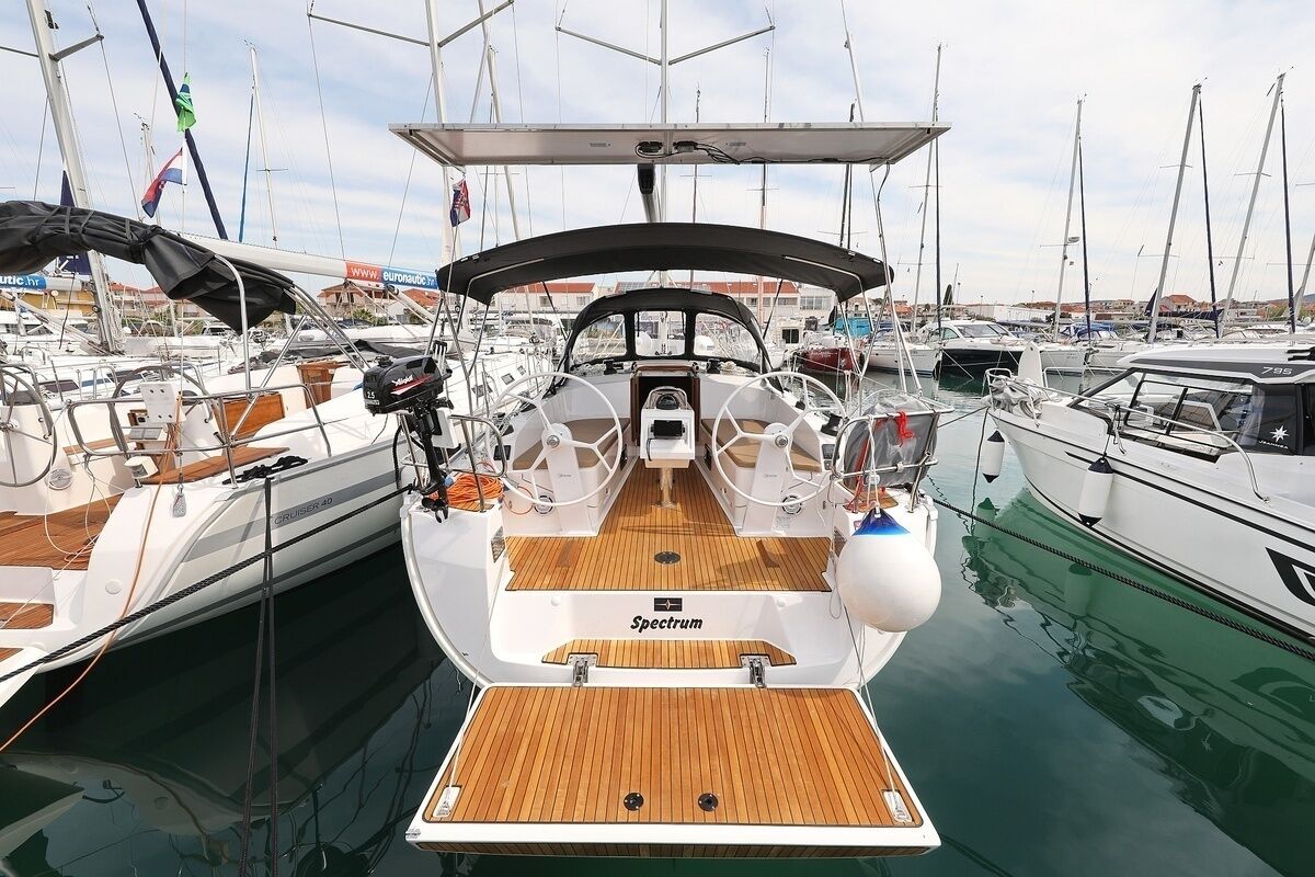 A boat with a wooden deck, steering wheel, and name 'Spectrum' visible.