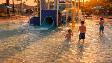 Parque acuático con tobogán de agua y estructuras de juego.