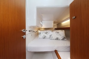 A compact cabin with a bunk bed, a small overhead shelf, and a door with a handle. - Sun-Kissed Sailing Adventure in Zadar, Croatia (Biograd na moru)